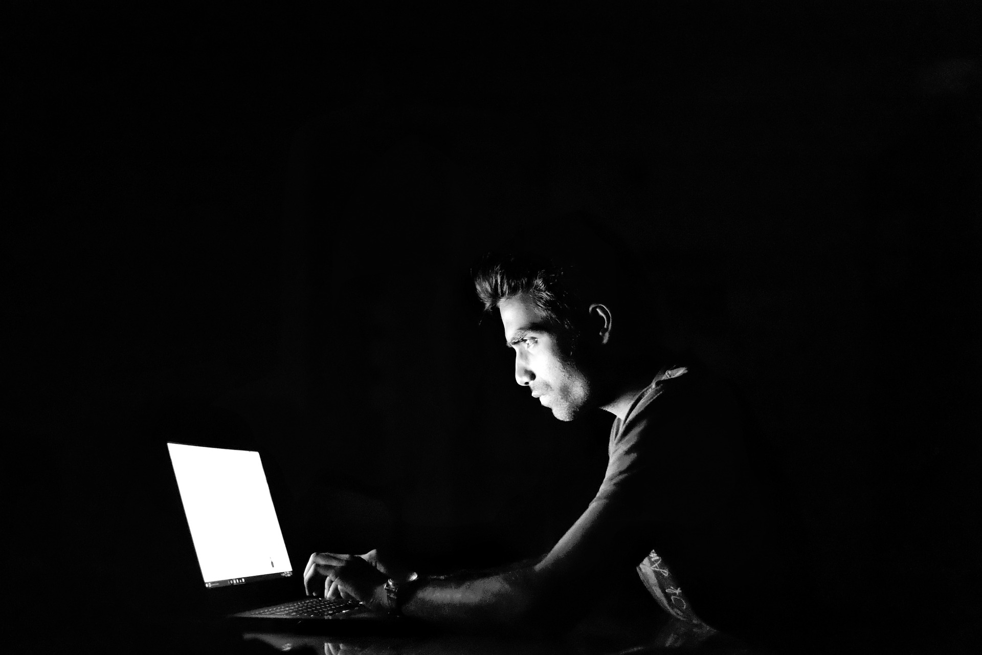 Schwarz-Weiss-Bild von Typ vor dem Laptop