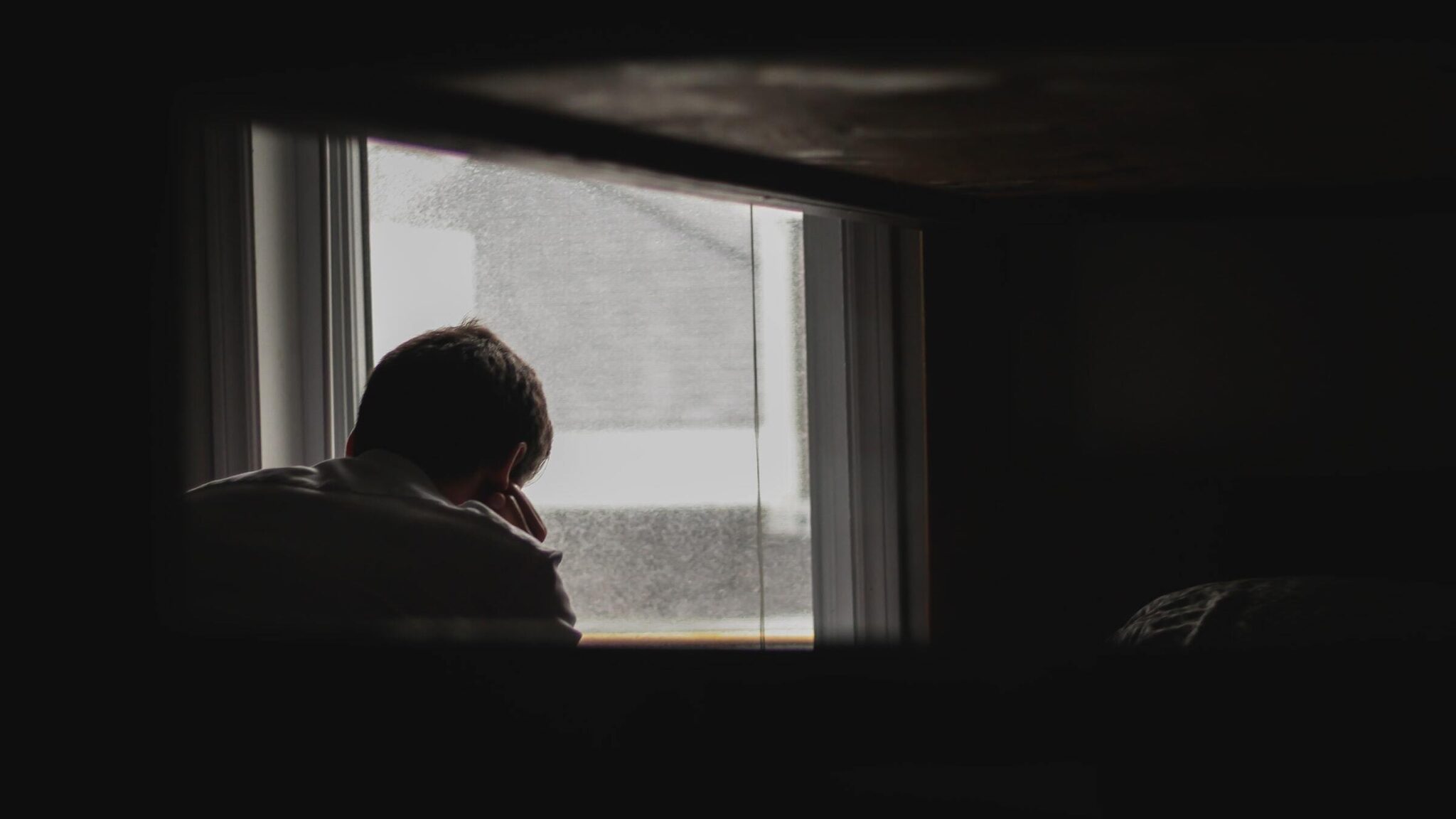 Silhouette eines Mannes vor einem Fenster