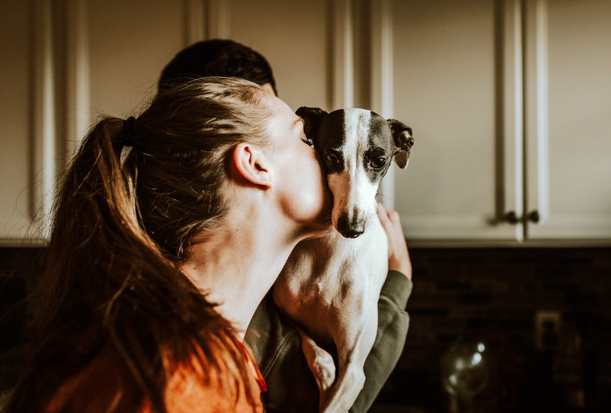 Eine Frau küsst ihren Hund.