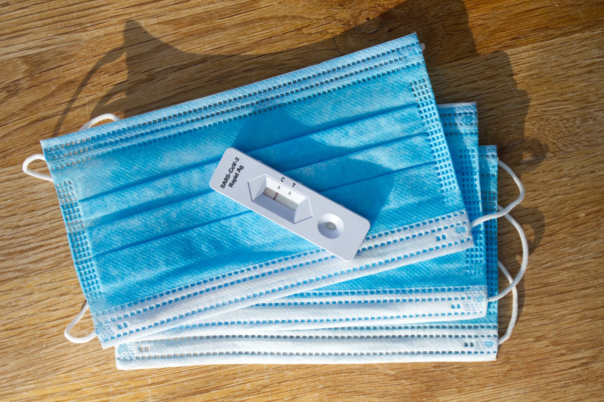 Teststreifen eines Selbsttests auf einem Stapel blauer Hygienemasken