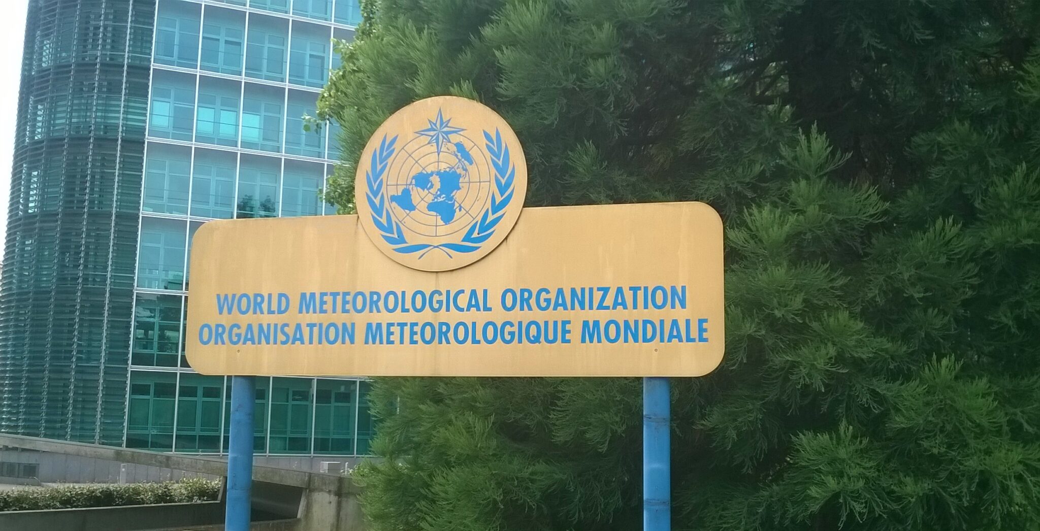 Goldfarbenes Schild der WMO mit blauer Schrift.