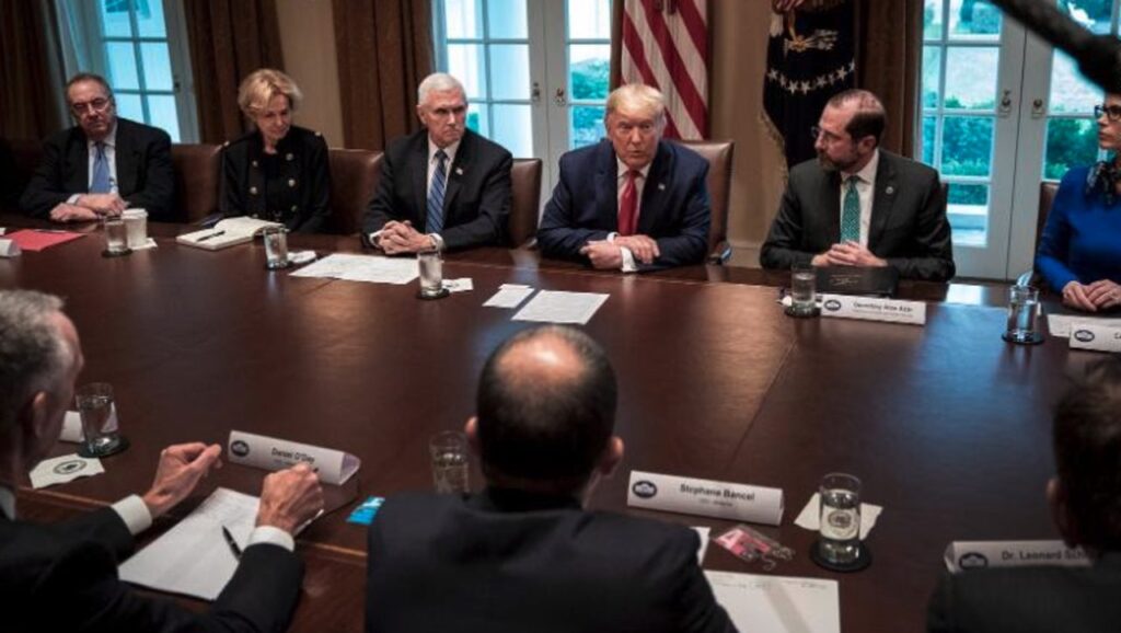 In einem Konferenzraum des Weissen Hauses sitzt Donald Trump mit mehreren Experten.