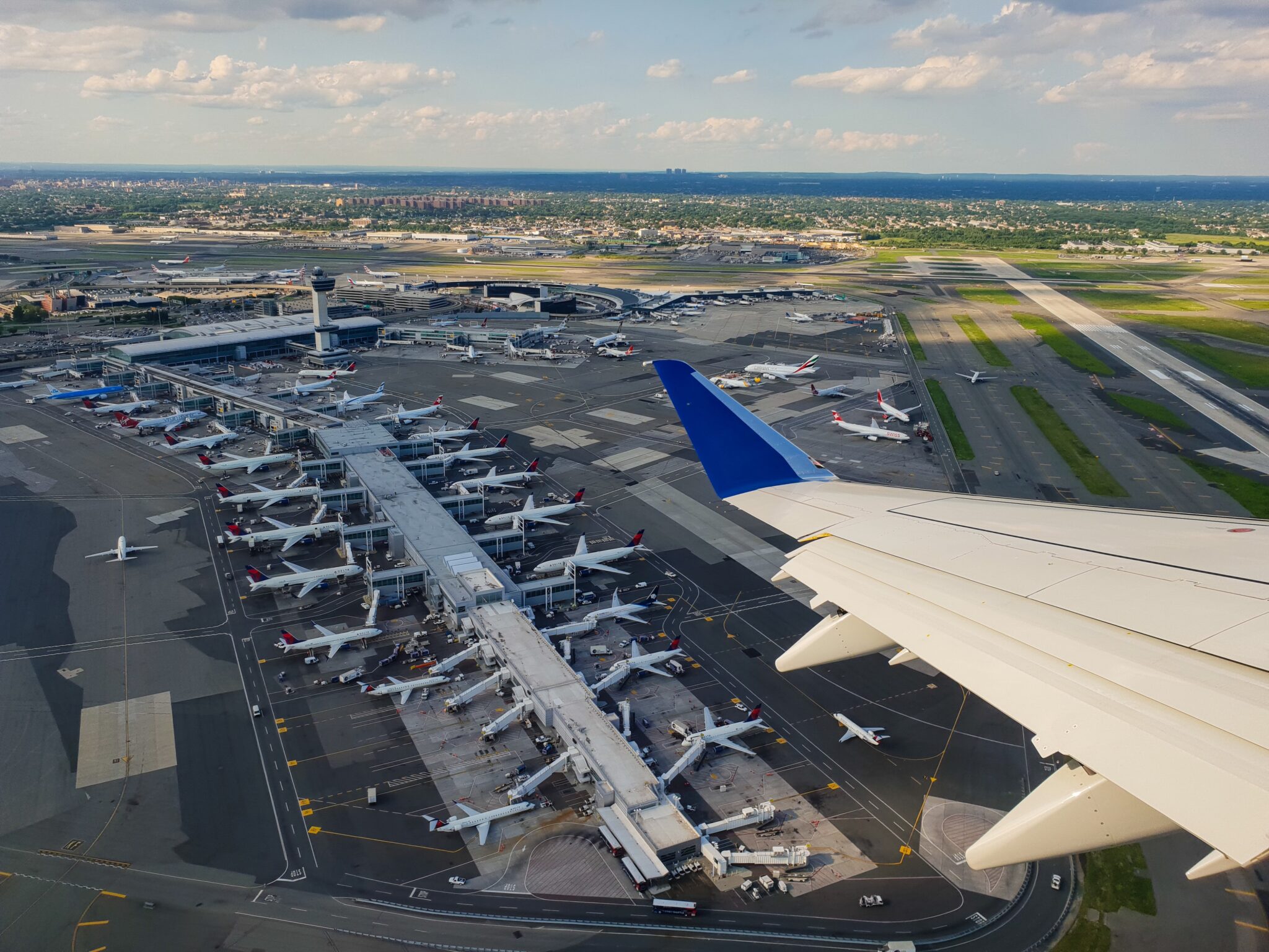 Blick aus einem Flugzeug auf den Boden mit vielen Stehenden Flugzeugen.