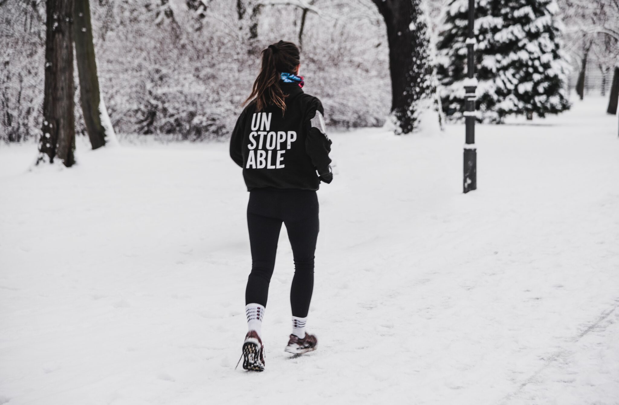 Eine Frau joggt im Schnee.