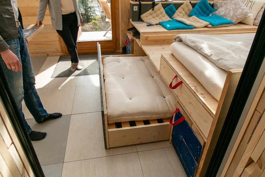 Eine Matratze verschwindet unter dem Wohnbereich in einem grossen Schubfach.